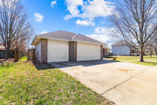 view of side of property with fence, driveway, an attached garage, a lawn, and brick siding