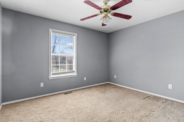 spare room featuring visible vents, baseboards, carpet, and ceiling fan