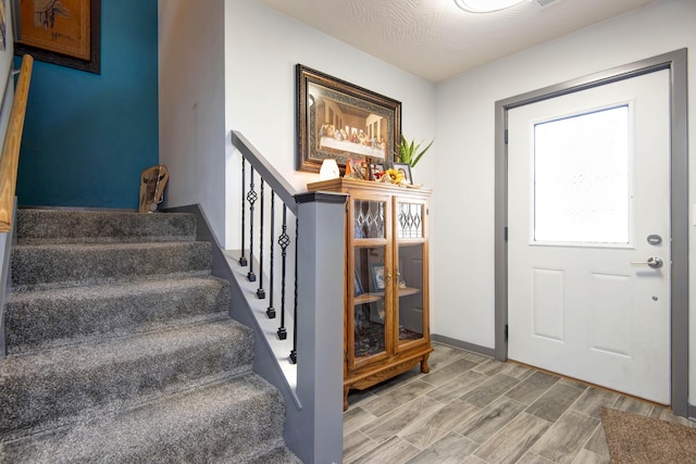 entryway featuring stairs and wood finished floors