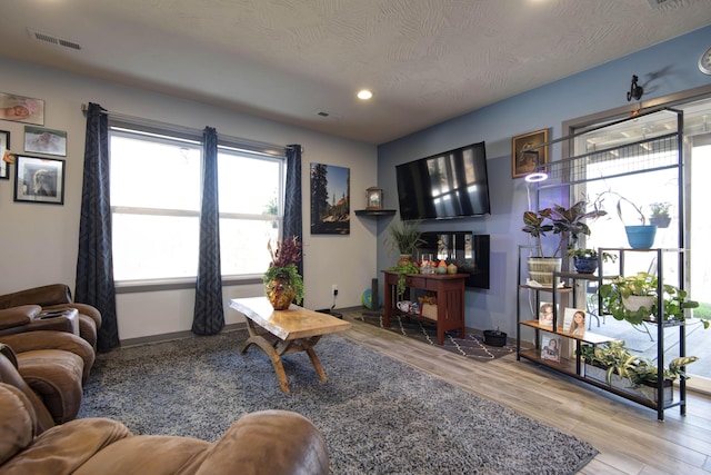 living room featuring recessed lighting, visible vents, baseboards, and wood finished floors