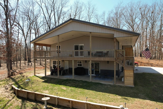 rear view of property featuring a yard, a deck, and a patio area