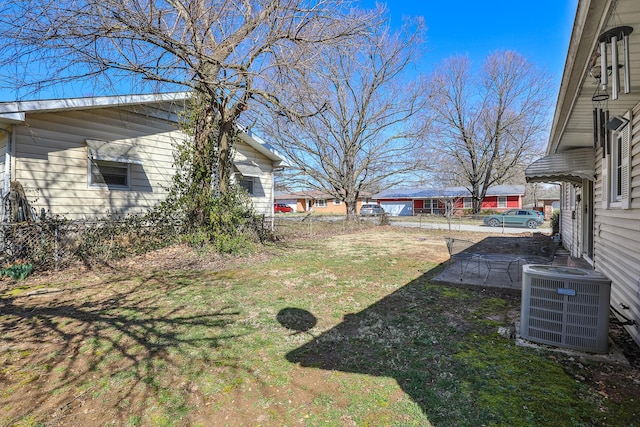 view of yard with central AC and fence