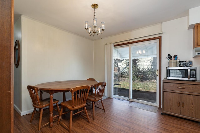 dining area featuring dark wood-style flooring and a chandelier