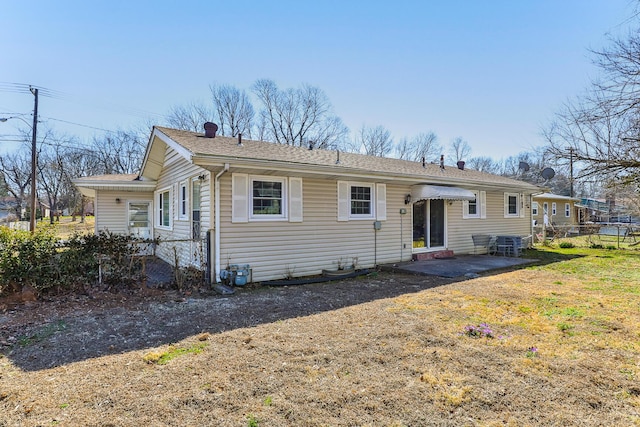 view of front of home featuring a patio, a chimney, a front lawn, and a shingled roof