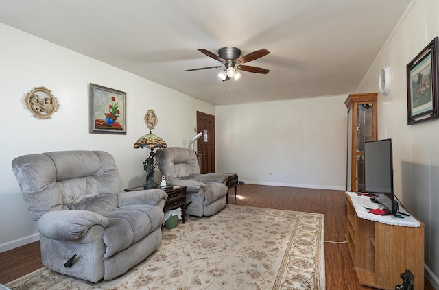 living area featuring baseboards, ceiling fan, and dark wood finished floors