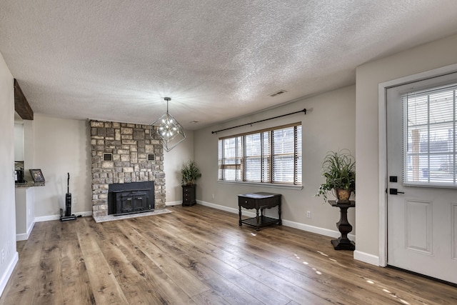 living area with visible vents, a healthy amount of sunlight, baseboards, and wood-type flooring