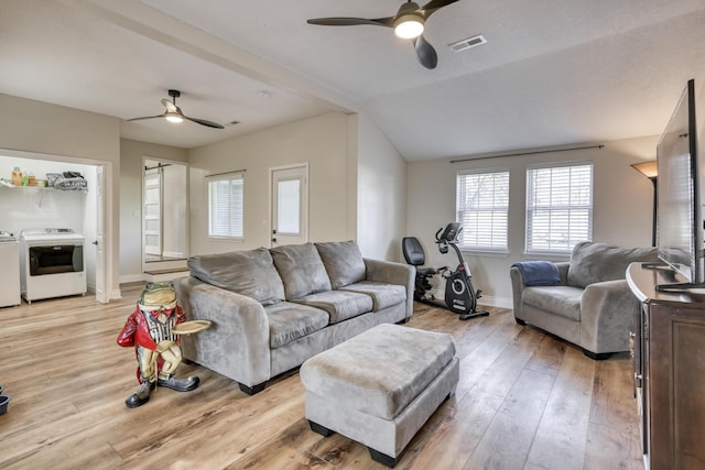 living area featuring washing machine and clothes dryer, visible vents, light wood-style floors, and ceiling fan