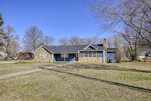 view of front facade with a shingled roof, a front lawn, stone siding, and a chimney