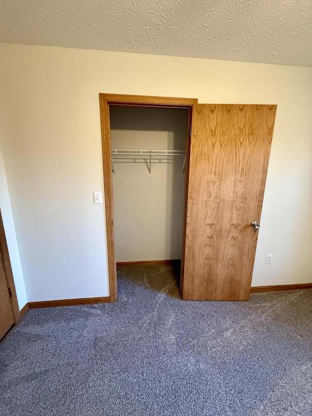 unfurnished bedroom with a closet, carpet, and a textured ceiling