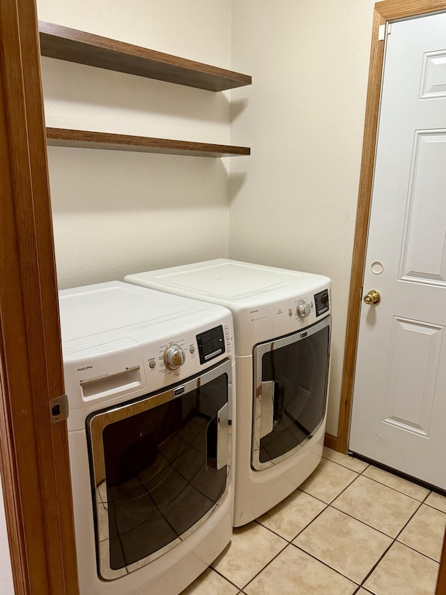 washroom with light tile patterned floors, independent washer and dryer, and laundry area