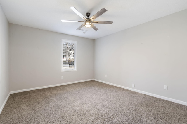 carpeted empty room featuring baseboards and a ceiling fan