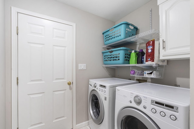 clothes washing area with cabinet space and separate washer and dryer