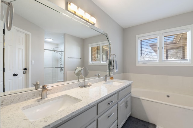 bathroom with plenty of natural light, a stall shower, and a sink