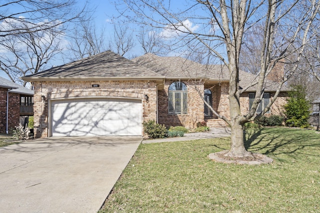 view of front of property with brick siding, driveway, a front yard, and a garage