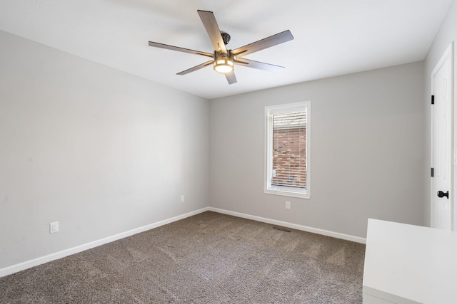 carpeted spare room featuring visible vents, baseboards, and ceiling fan