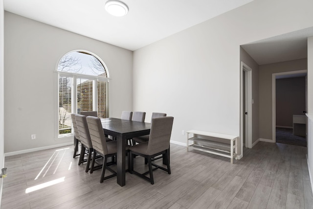 dining space with light wood-style flooring and baseboards