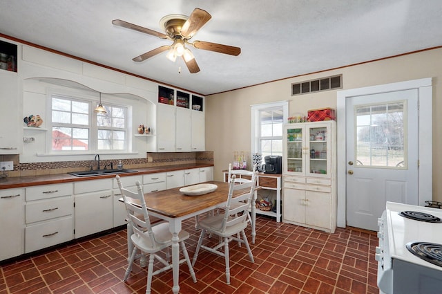 kitchen with white electric range oven, visible vents, open shelves, a sink, and white cabinets