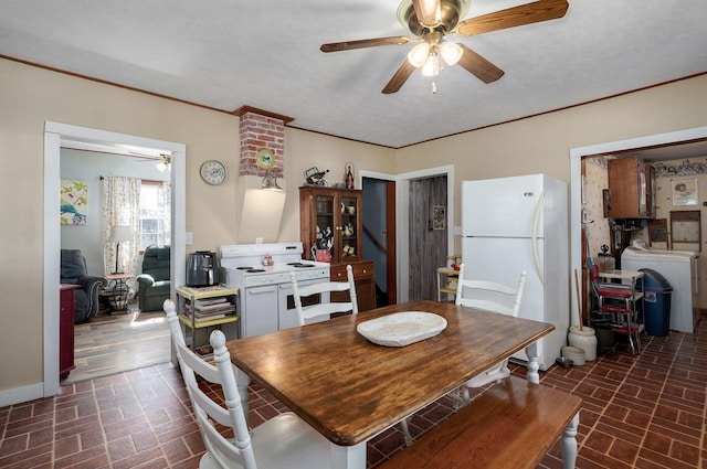 dining room with brick floor, washer / dryer, ceiling fan, and ornamental molding