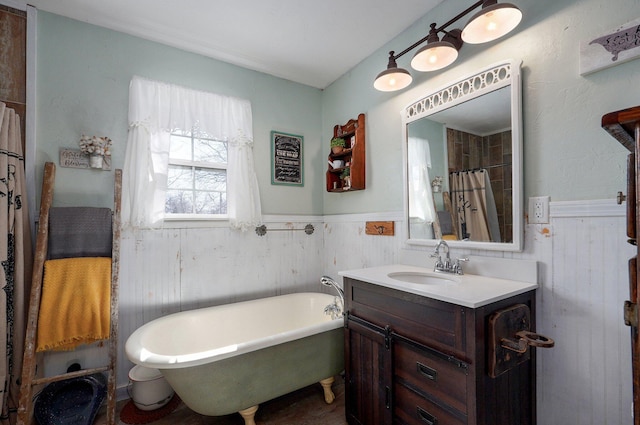 bathroom with vanity, a freestanding tub, and wainscoting