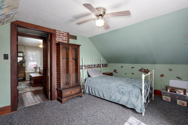 carpeted bedroom featuring visible vents, a textured ceiling, ceiling fan, and vaulted ceiling