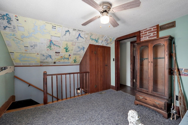 unfurnished bedroom featuring carpet flooring, a textured ceiling, ceiling fan, and vaulted ceiling