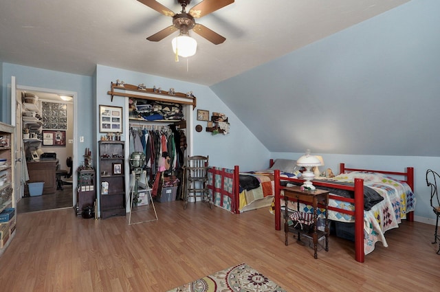 bedroom featuring a closet, a ceiling fan, lofted ceiling, and wood finished floors