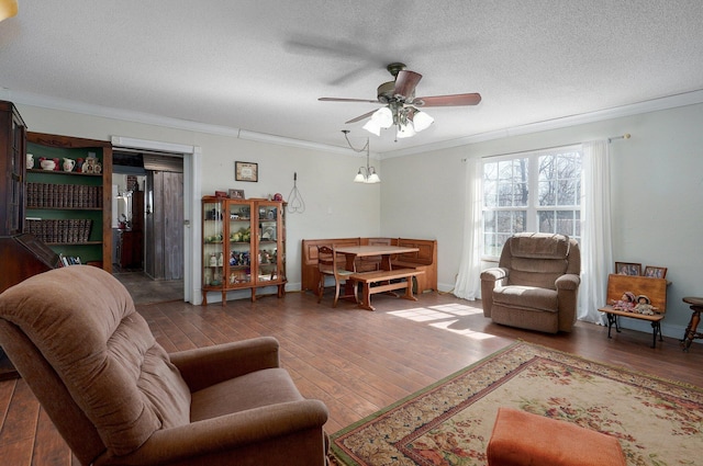 living room with ornamental molding, a textured ceiling, hardwood / wood-style floors, baseboards, and ceiling fan