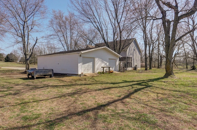 view of property exterior featuring an outbuilding, a lawn, and a detached garage