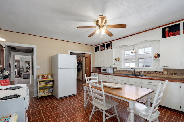 kitchen with white appliances, open shelves, ceiling fan, a sink, and white cabinets