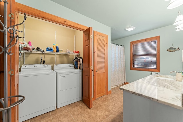 laundry area featuring a sink, light tile patterned floors, laundry area, and washer and dryer