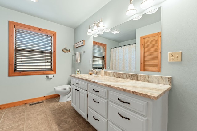 bathroom with vanity, visible vents, baseboards, tile patterned flooring, and toilet