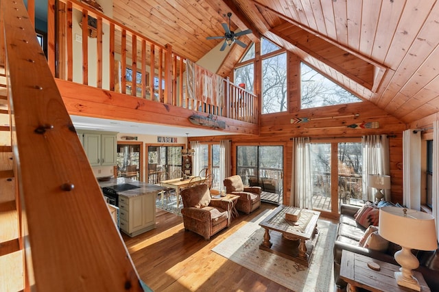 living area featuring wooden ceiling, lofted ceiling with beams, wood finished floors, and ceiling fan