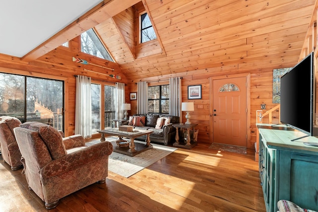 living area with wooden walls, wood finished floors, and high vaulted ceiling