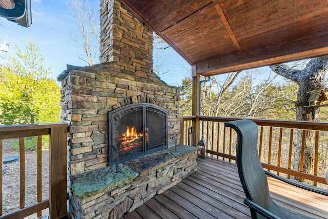 wooden deck with an outdoor stone fireplace