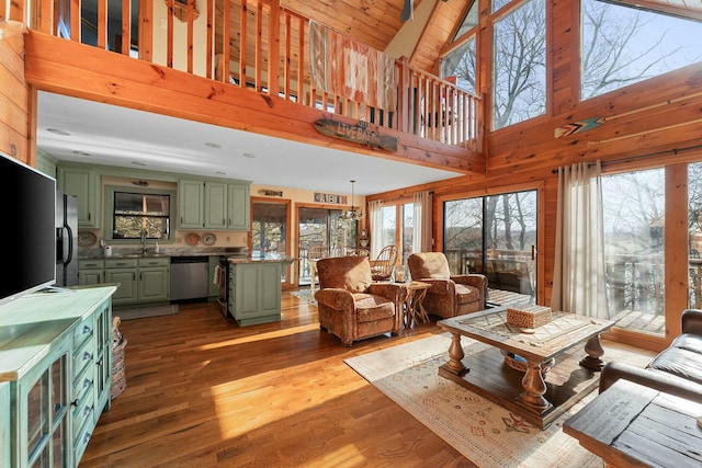 living area with wooden walls, wood finished floors, and beamed ceiling