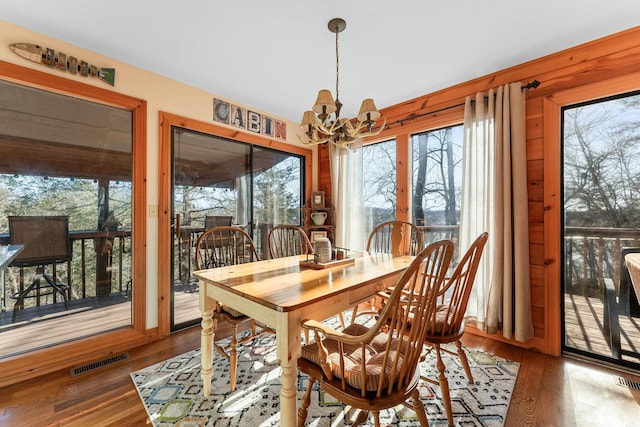 dining space featuring a notable chandelier, wood finished floors, and visible vents