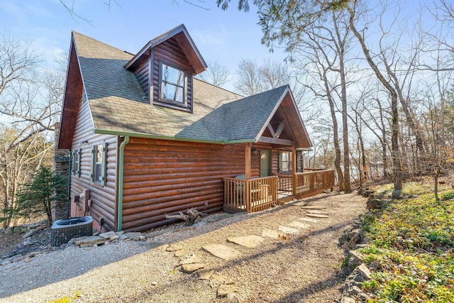 view of front of property with log veneer siding, central air condition unit, and roof with shingles