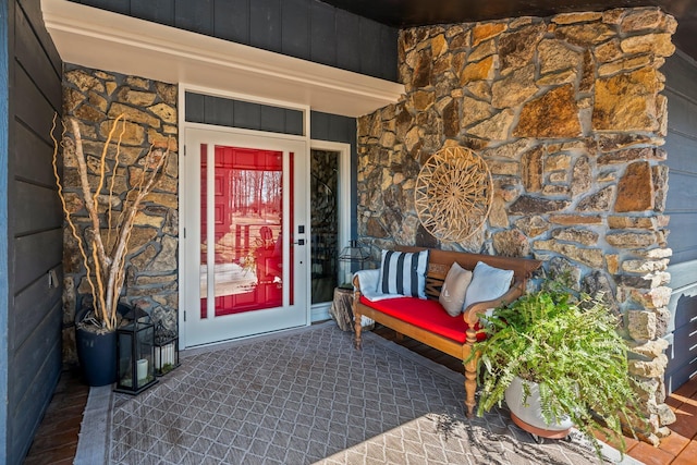 doorway to property featuring stone siding and board and batten siding