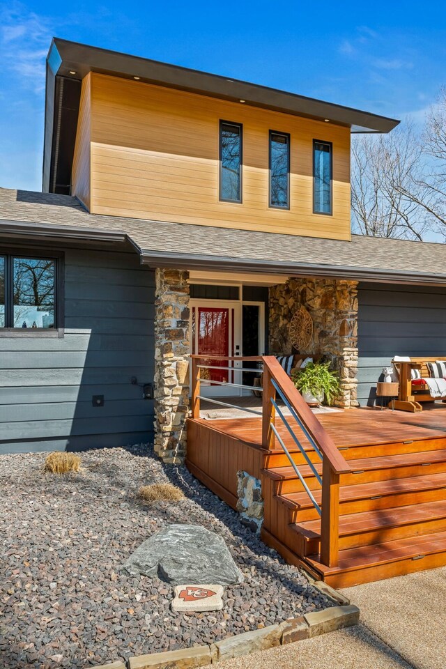 view of front of home featuring stone siding, covered porch, and an attached garage