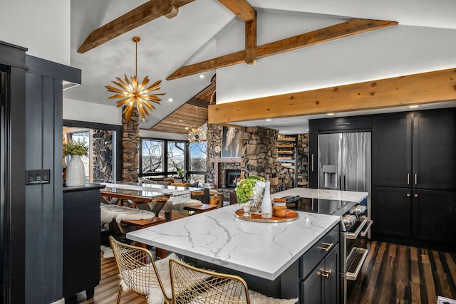 kitchen with dark wood-type flooring, a notable chandelier, dark cabinetry, a center island, and stainless steel appliances