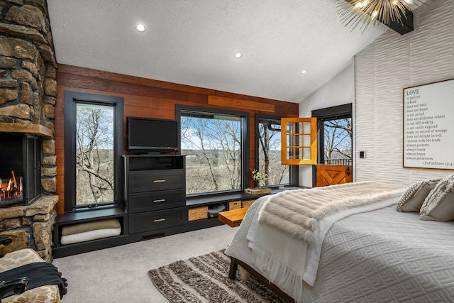 bedroom with multiple windows, carpet floors, a textured ceiling, and vaulted ceiling