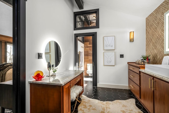 bathroom featuring tile patterned flooring, vaulted ceiling with beams, baseboards, toilet, and vanity