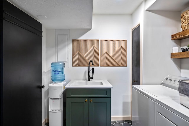 laundry room featuring a textured ceiling, laundry area, separate washer and dryer, and a sink