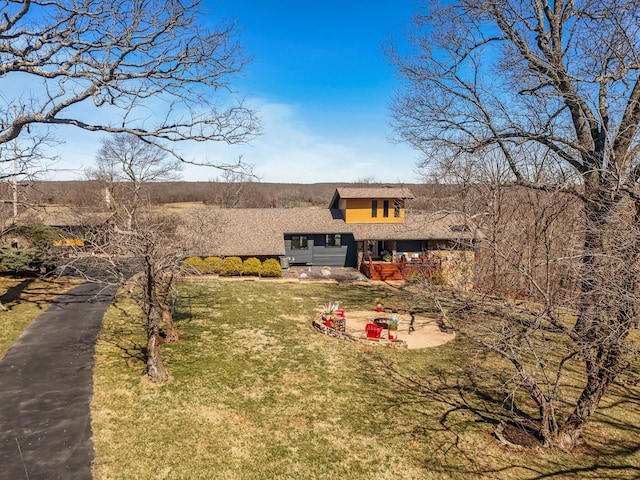 exterior space with a front lawn and roof with shingles