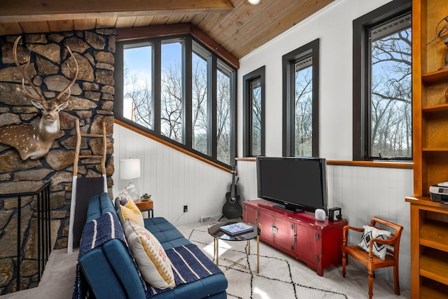 living room featuring a stone fireplace, wooden ceiling, and vaulted ceiling