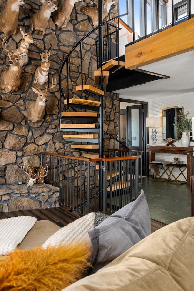 unfurnished living room featuring stairs, a high ceiling, and wood finished floors