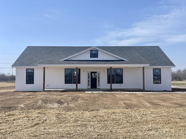 modern farmhouse style home featuring a porch and roof with shingles