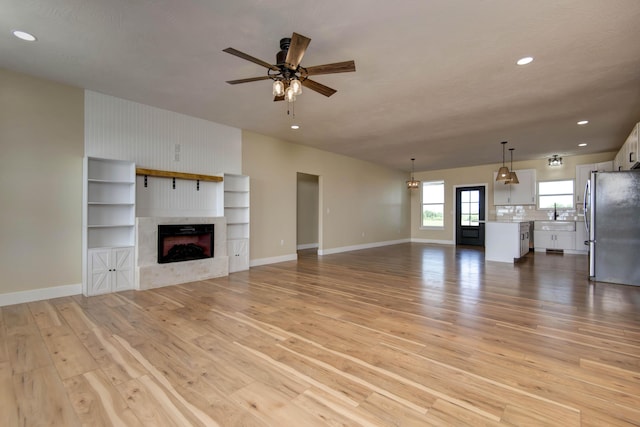 1883 S Farm Rd Unit 107, Springfield, MO 65802 - unfurnished living room with light wood finished floors, ceiling fan, recessed lighting, baseboards, and a fireplace