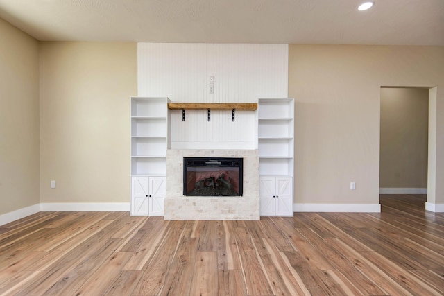 1883 S Farm Rd Unit 107, Springfield, MO 65802 - unfurnished living room featuring wood finished floors, baseboards, a tiled fireplace, and recessed lighting