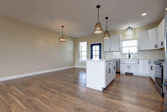 1883 S Farm Rd Unit 107, Springfield, MO 65802 - kitchen featuring a sink, tasteful backsplash, stainless steel appliances, a kitchen island, and decorative light fixtures